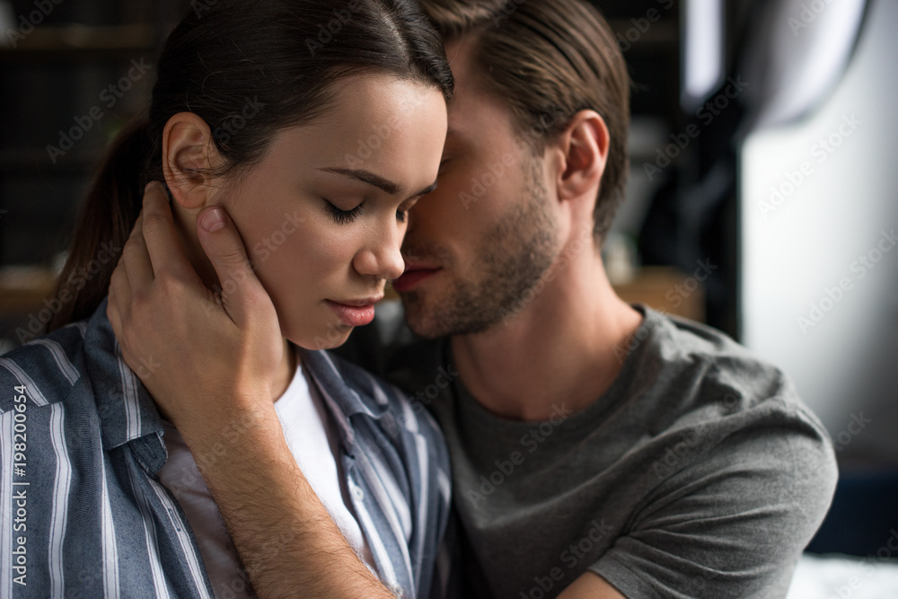 Obraz premium Bearded man embracing attractive brunette wife