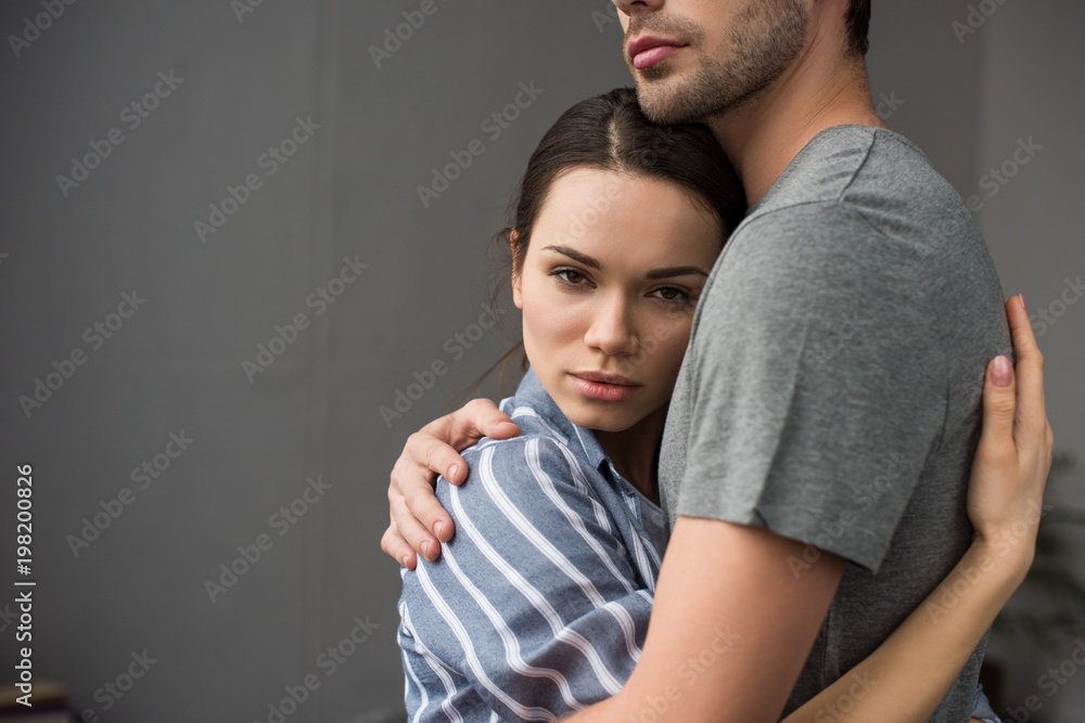 Brunette woman hugging her husband in bedroom
