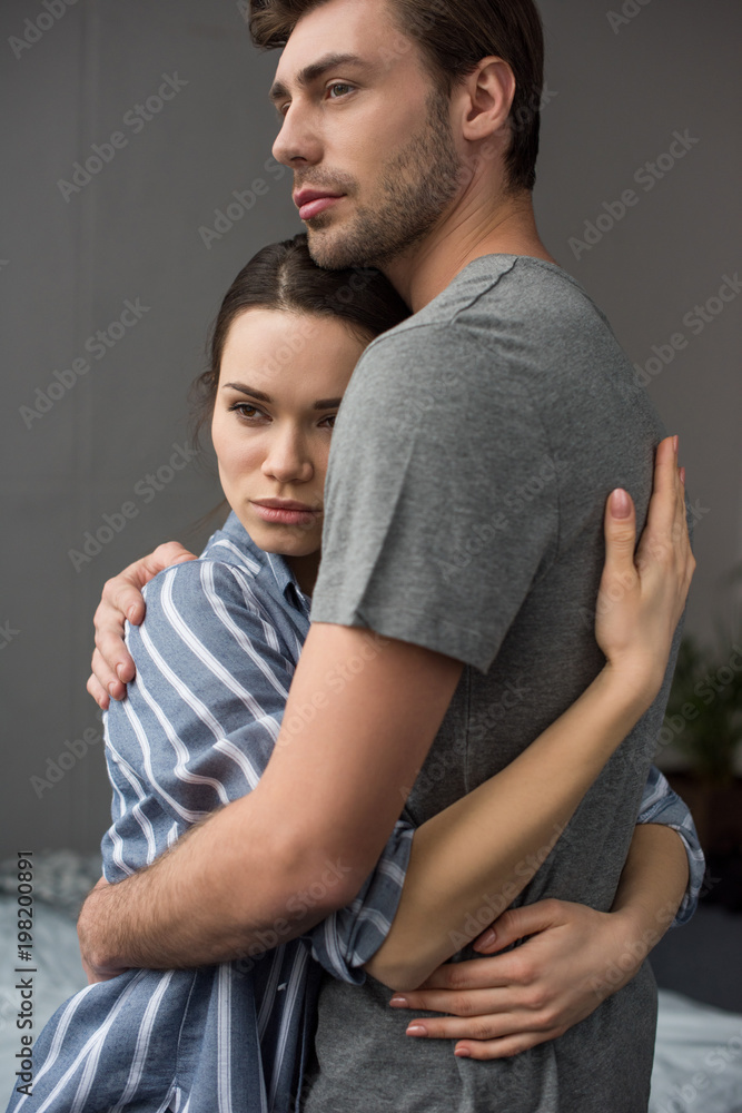 Young attractive couple hugging in bedroom Young attractive couple hugging in bedroom