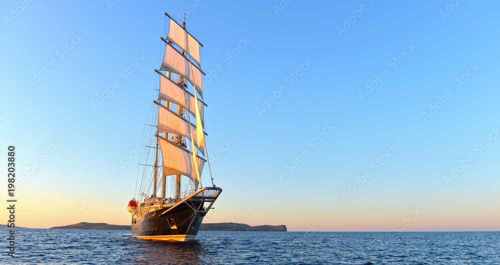 Naklejka premium Sailing ship and beautiful sunset in the sea. Yachting. Sailing