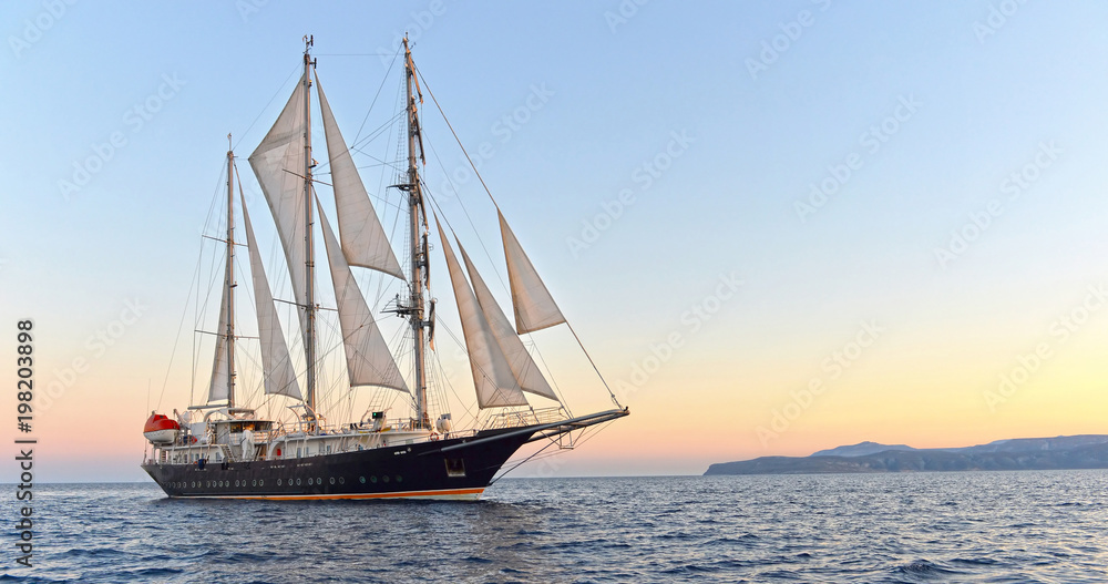 Sailing ship and beautiful sunset in the sea.  Yachting. Sailing