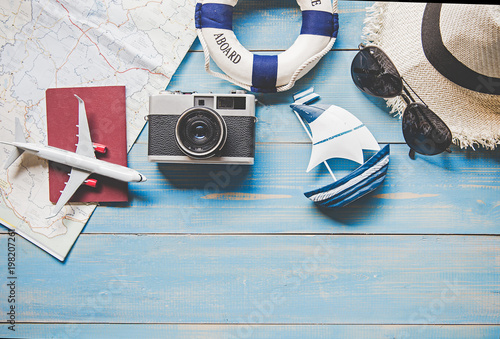 Travel Plan. Traveler planning trip summer travel on the beach with Traveler's accessories, retro camera, airplane and passport,  vintage tone style.  Travel and Summer Concept. photo