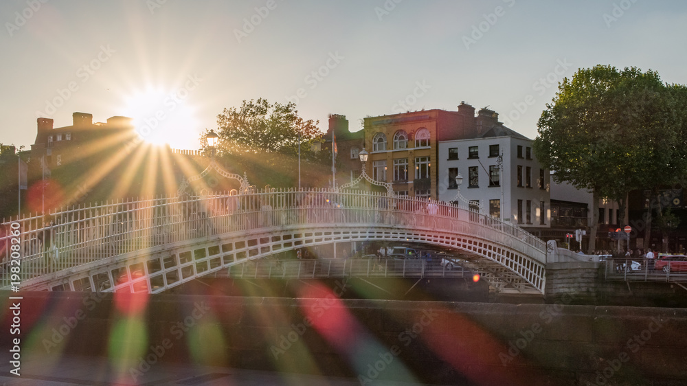 Obraz premium Half Penny Brücke über den Fluss Liffey in Dublin mit Sonnenstrahlen und Blendenflecken
