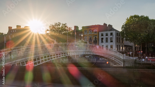 Half Penny Brücke über den Fluss Liffey in Dublin mit Sonnenstrahlen und Blendenflecken