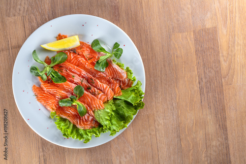 salted salmon with a slice of lemon on a sheet of green salad