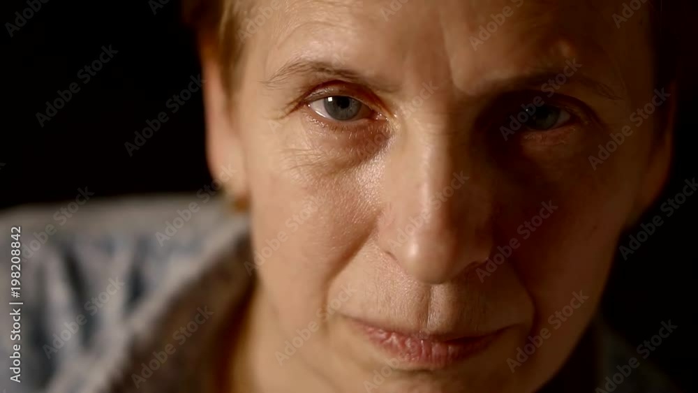 Close up. Portrait of an old elderly woman looking at the camera and blinking. Close up. Portrait of an old elderly woman looking at the camera and blinking.