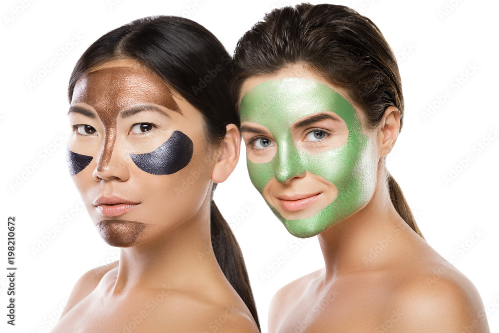 Two beautiful girls with colorful peel-off masks on their faces Two beautiful girls with colorful peel-off masks on their faces