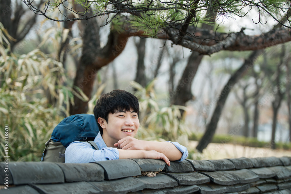 A young man doing a backpacking trip in a Korean traditional house. A young man doing a backpacking trip in a Korean traditional house.