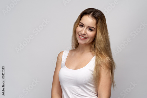 shot of a cute female model on isolated white background. A beautiful blonde girl is happy to receive compliments from a man.