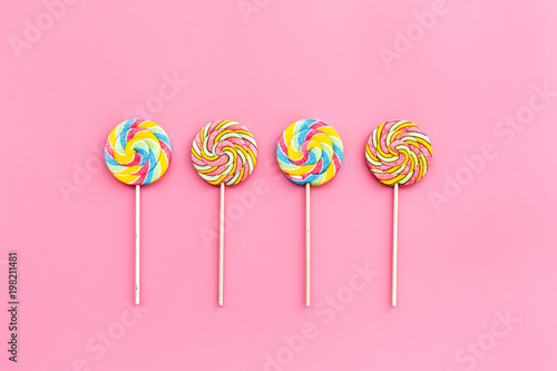 Sweets for party background. Lollipop on pink top view copy space
