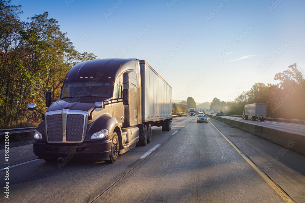 18 wheeler semi truck on highway with sun lens flare