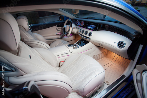 Luxury car interior. Steering wheel, shift lever and dashboard. photo