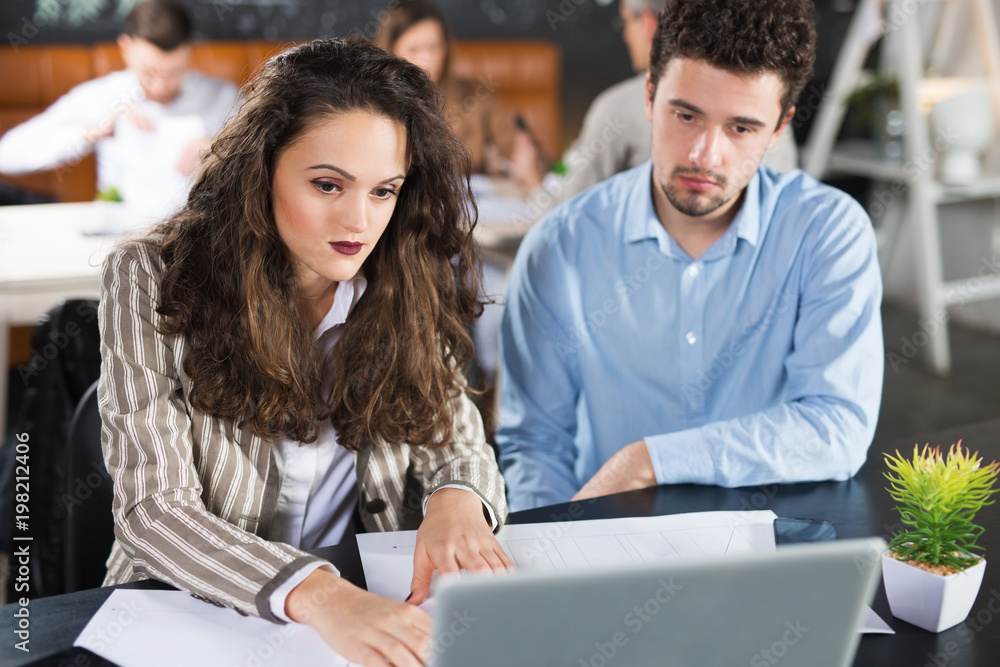 Young colleagues working together in a cafe