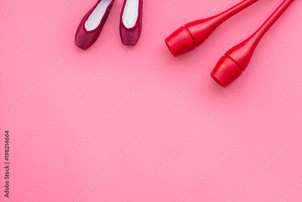 Beauty sport for girls concept. Maces for rhythmic gymnastics and ballet shoes on pink background top view copy space