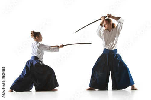 Fényképezés Man and woman fighting and training aikido on white studio background