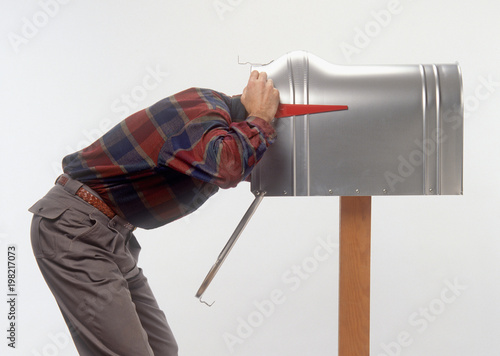 humorous funny profile of bent over man with head in mailbox  photo