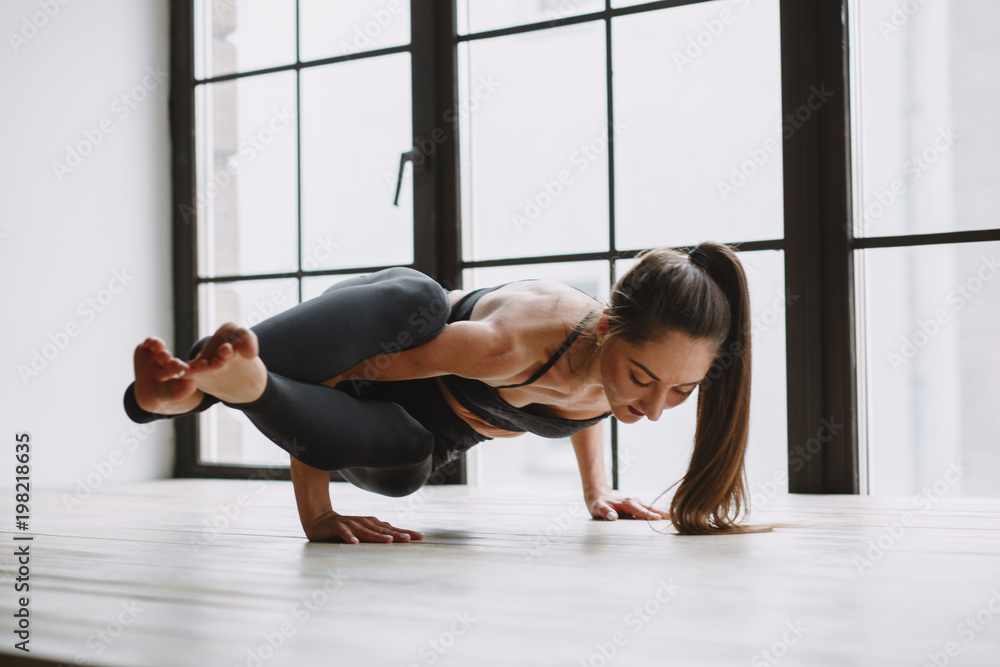 Young woman doing yoga at light window Young woman doing yoga at light window