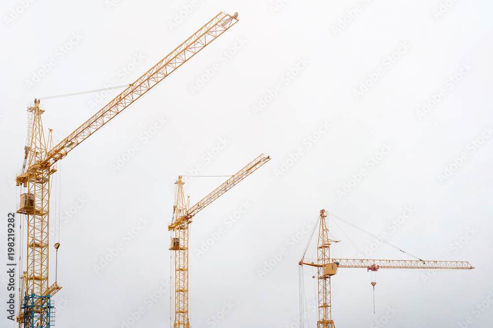 Construction cranes on the construction site, standing at home