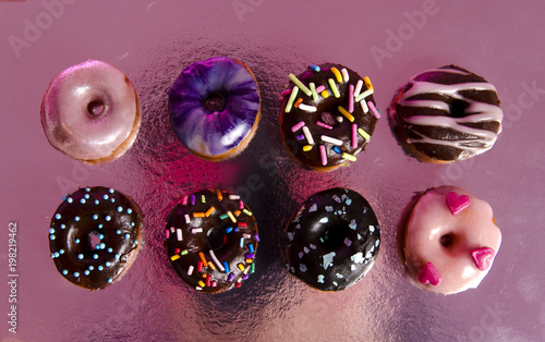 Eight delicious mini donuts, top view on reflected surface  © phoenix021