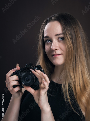 Beautiful young girl with retro camera. Portrait of a girl photographer