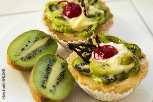 Delicious fruit cake with curd cream with kiwi and cherry