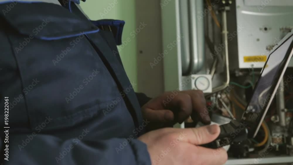 Worker checking gas-fire boiler Worker checking gas-fire boiler