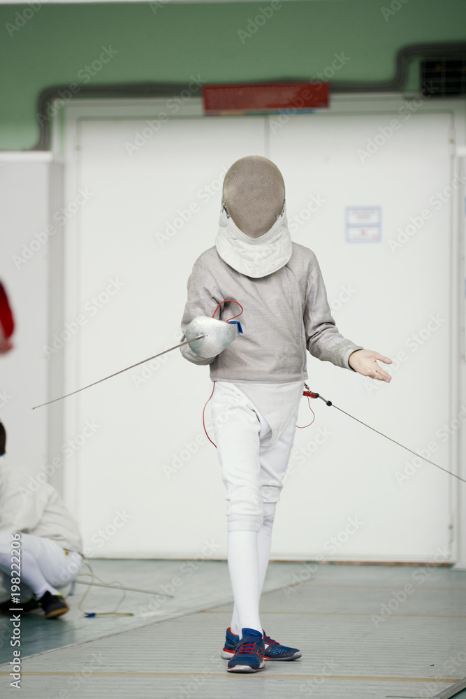 Young fencer in special costume at the fencing competition with rapier