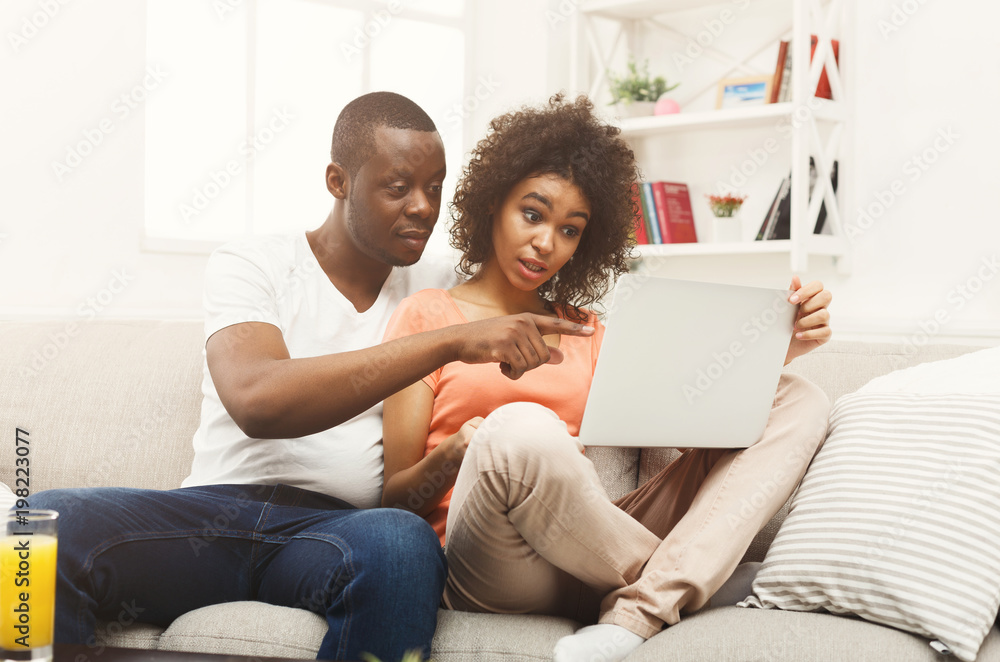 Young african-american couple working on laptop Young african-american couple working on laptop