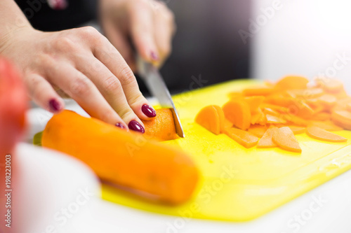 Cutting carrots for salad in the kitchen.