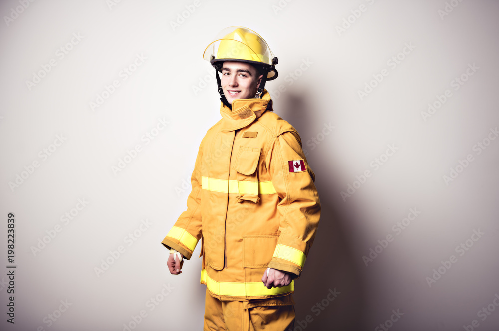 Picture from a young firefighter on studio white wall Picture from a young firefighter on studio white wall