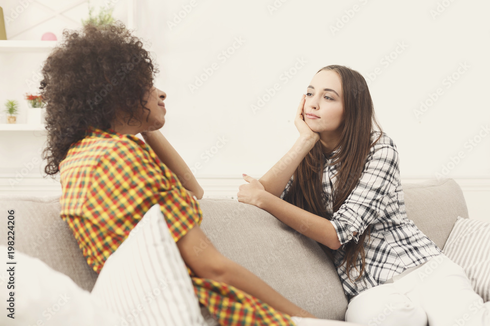 Two young female friends with coffee conversing Two young female friends with coffee conversing