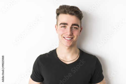 portrait of young smiling cute teenager in white wall © Louis-Photo