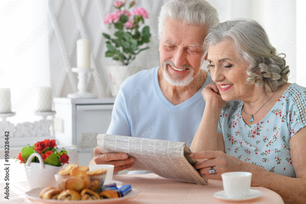 senior couple with newspaper at home