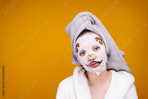 young girl with a towel on her head looking at the camera  on the face mask with a dog face