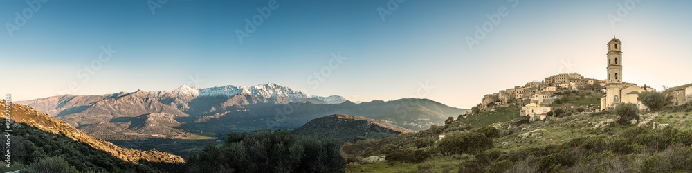 Panoramic view of Sant' Antonino and snow capped mountains in Corsica