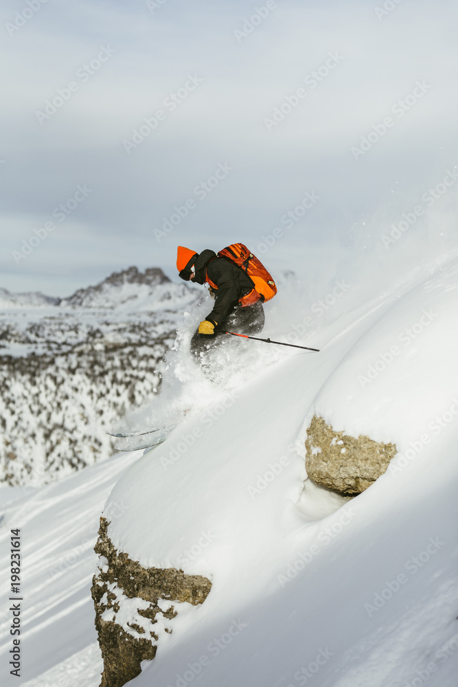 Side view of hiker with backpack skiing on snowcapped mountain Side view of hiker with backpack skiing on snowcapped mountain
