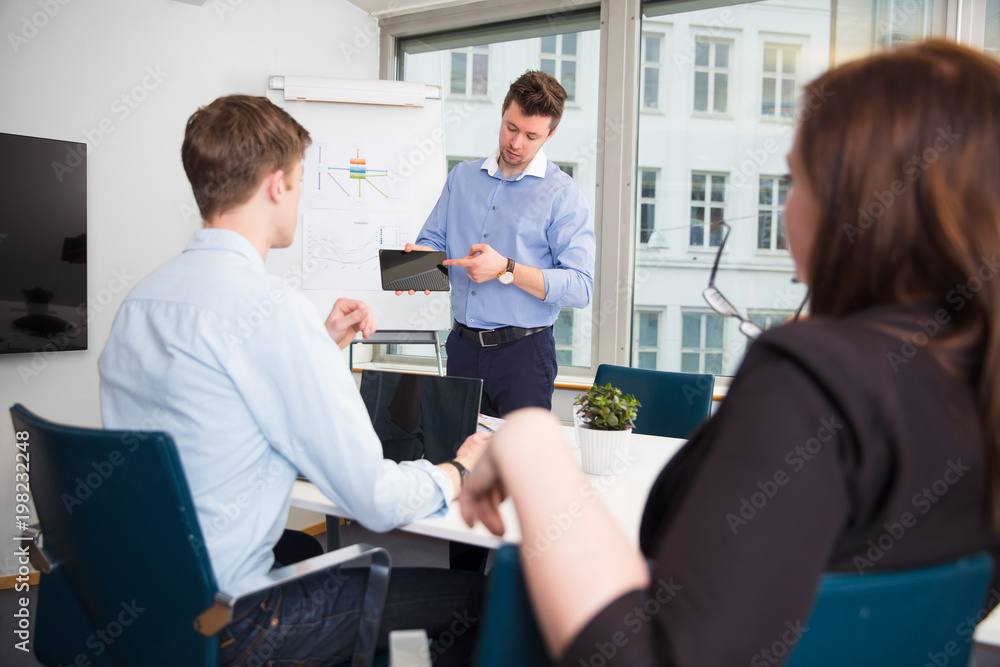Obraz premium Businessman Showing Tablet Computer To Coworkers