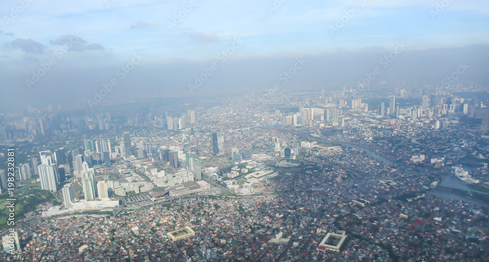 A view of the city of Manila through the window from the plane. Impressed photo of a tourist in flight over the capital. Philippines.