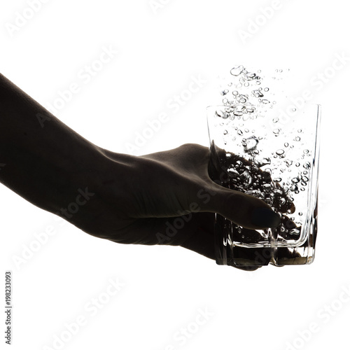 silhouette of a female hand with a glass of water, concept of clean water and health care