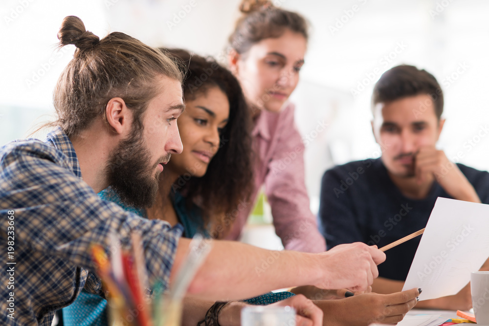 Fototapeta premium Young multiethnic creative team sharing ideas on a project 