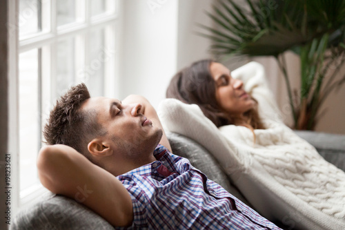 Fotografie Young couple resting on comfortable couch together at home, happy man and woman