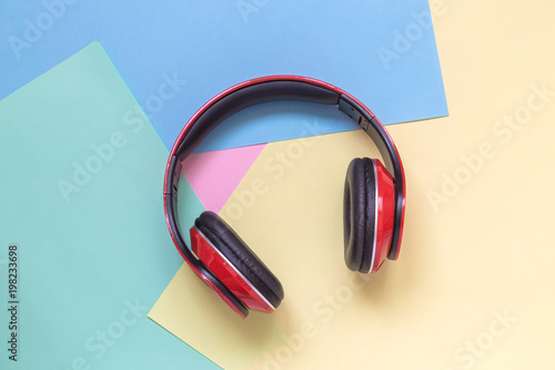 Close up of read headphones on multicolored background. Music minimal concept