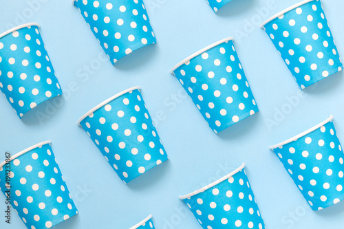 Diagonally positioned paper cups isolated on blue background. Minimalistic fashionable concept.