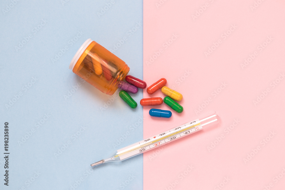 Multicolored medicines and thermometer isolated on pastel background minimalistic flat lay concept. Multicolored medicines and thermometer isolated on pastel background minimalistic flat lay concept.
