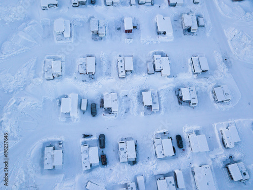 Aerial winter view of camping place with caravans, trailer park and cabin cottage houses, northern Sweden, near border with Norway