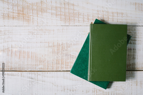 green books lie on a wooden table. top view