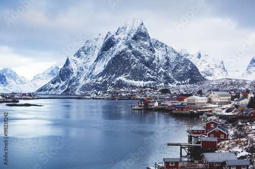 Beautiful super wide-angle winter snowy view of Reine, Norway, Lofoten Islands, with skyline, mountains, famous fishing village with red fishing cabins, Moskenesoya, Nordland photo