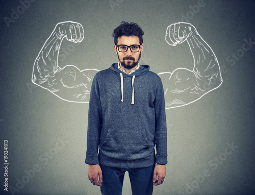 confident strong man hipster on wall background
