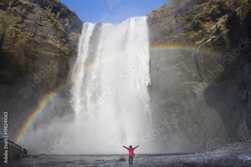 traveler enjoy road trip in Iceland with the biggest Skogafoss waterfall with rainbow