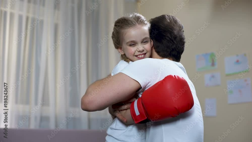 Proud man hugging smiling daughter in boxing gloves, good sport results, family Proud man hugging smiling daughter in boxing gloves, good sport results, family